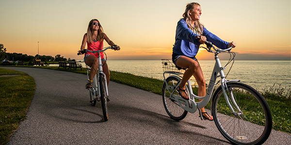 two girls riding rental bikes near the lake